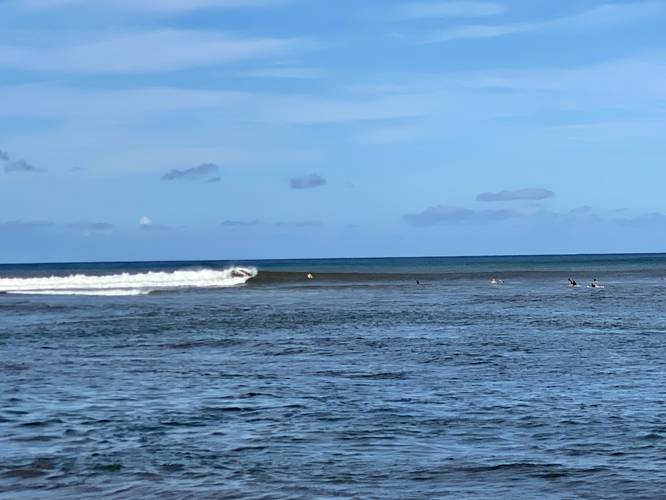 Surfers riding waves at Pakala Beach