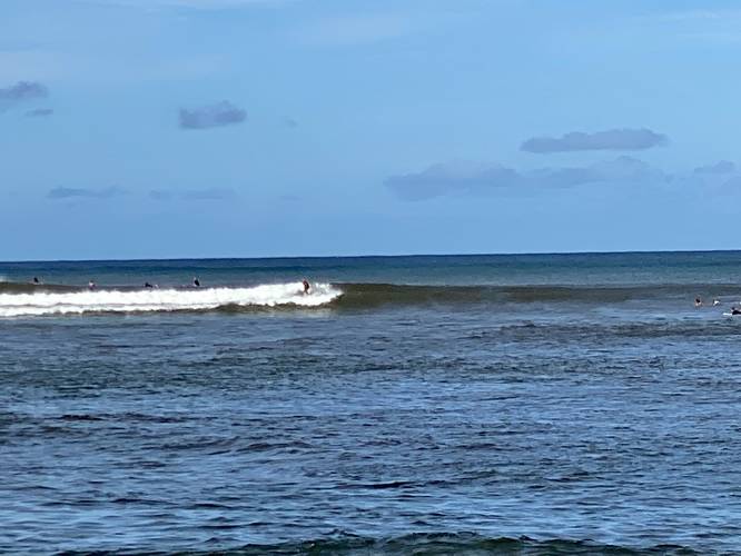 Surfers riding waves at Pakala Beach