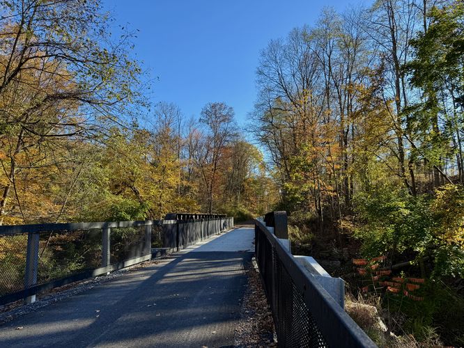 Foliage surrounds a bridge that spans Marsh Creek
