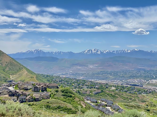 Snow-capped mountain views in the distance with a view of Bluffdale, Utah below from the summit of Potato Hill