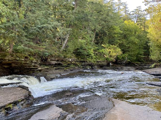 Fisherman and small waterfalls in the Presque Isle River
