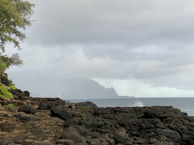 View of the Kauai coastline with spectators at Queen's Bath