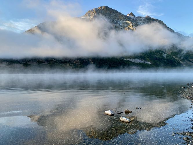Crystal-clear water of the lake with light and dark rocks in the water