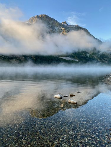 Portrait view of Saint Mary Lake with colorful rocks in the water