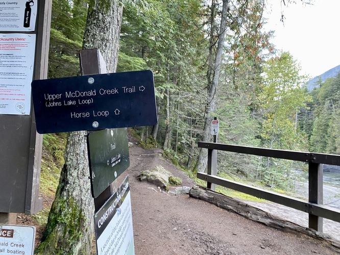 Trail sign leads across the bridge to reach McDonald Falls