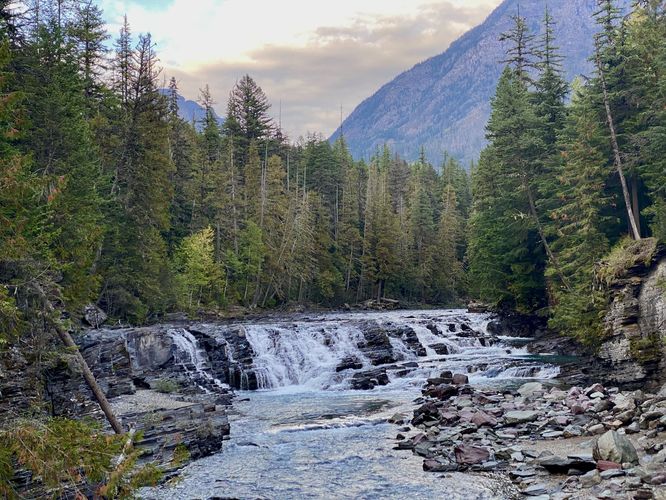 View of the Sacred Dancing Cascade waterfall in McDonald Creek from the footbridge