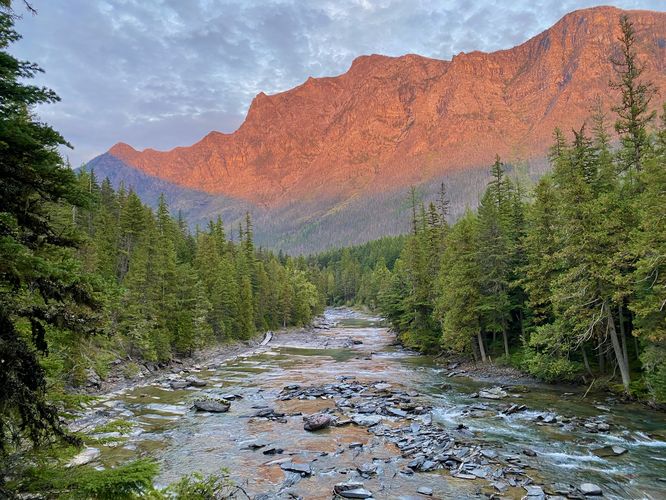 View of McDonald Creek with a sunset on Mount Brown