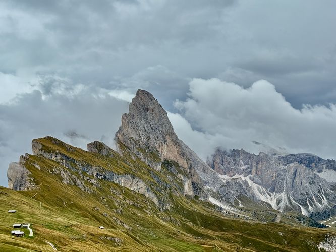 Clouds envelop the alpine peaks and ridges of Seceda Ridge