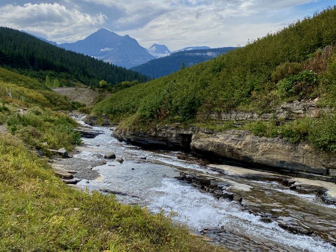 View looking down the slide waterfall with alpine mountains in the distance