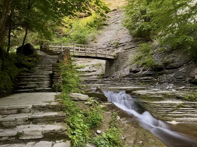 3-foot tall waterfall and a wooden footbridge (long exposure)