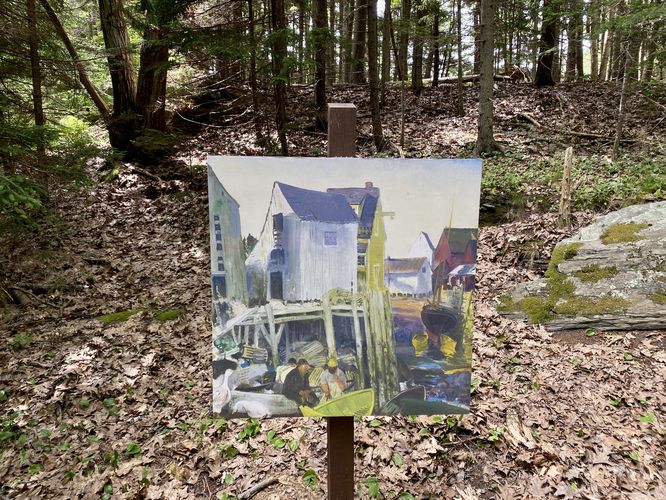 Re-printed painting on a stand on-trail of a harbor town