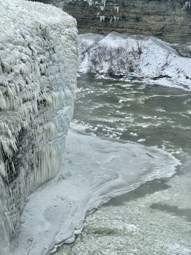 Portrait view of frozen waterfall spray clings to the 100-foot tall cliffs in the Letchworth Gorge