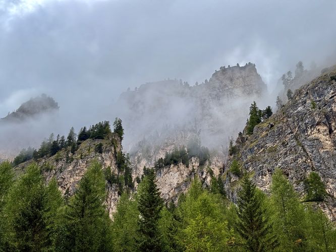 View of more alpine walls high above Vallunga with clouds rolling in