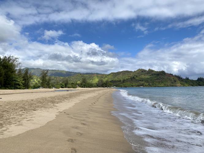View of Hanalei Bay mountain range and ocean from Waioli Beach, facing west