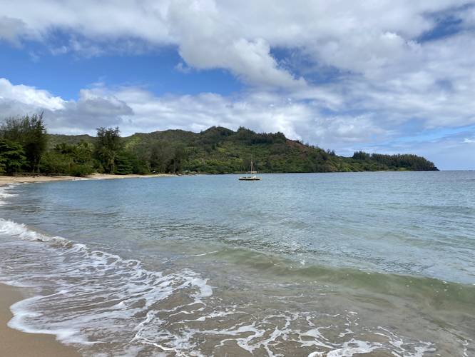 View of Hanalei Bay mountain range and ocean from Waioli Beach, facing west