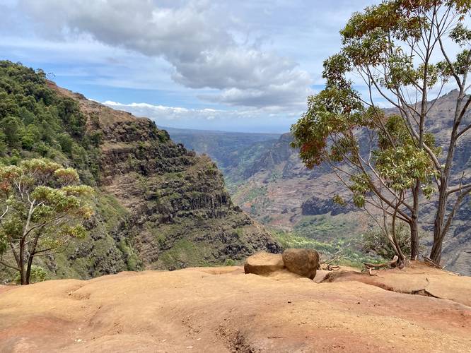 View into Waimea Canyon with circular holes in the rock on the cliff - likely from volcanic activity thousands of years ago