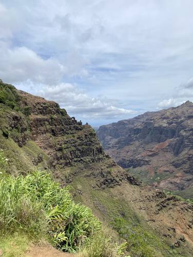 View into Waimea Canyon with circular holes in the rock on the cliff - likely from volcanic activity thousands of years ago